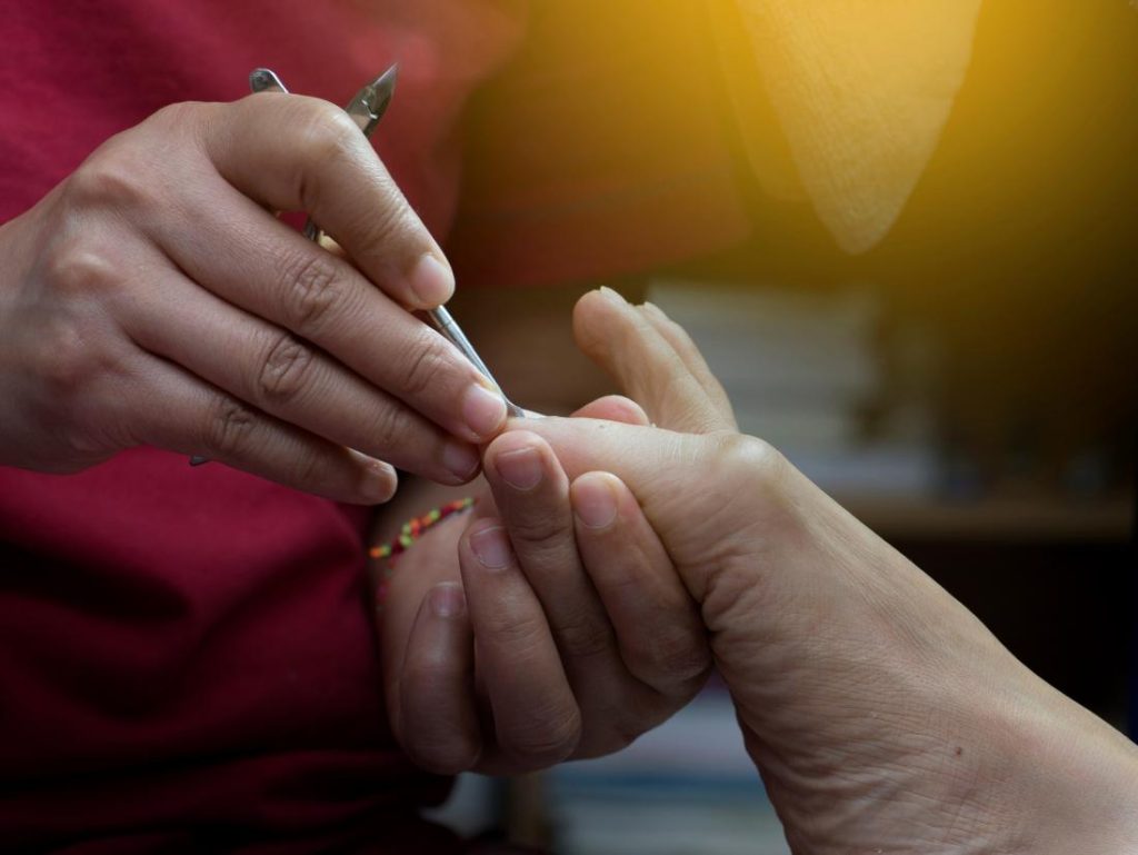 a-woman-showing-how-to-cut-an-ingrown-toenail